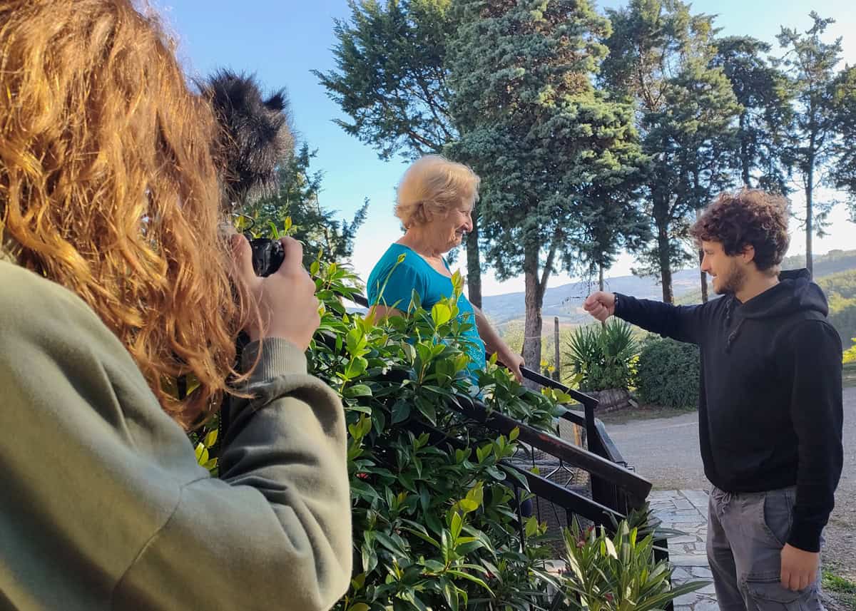 Una giovane creativa filma un'abitante del borgo durante la residenza